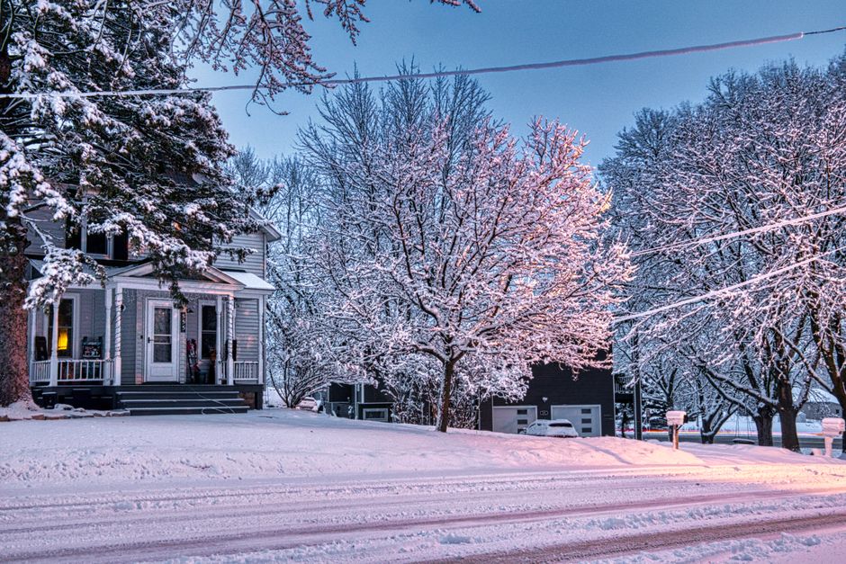 Snow-covered yard next to a basement foundation wall in Dane County