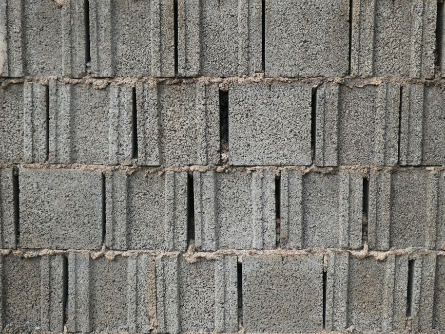 An open window well beside a basement window, uncovered