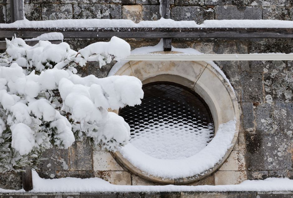Snow accumulated on top of a window well cover in a Wisconsin yard